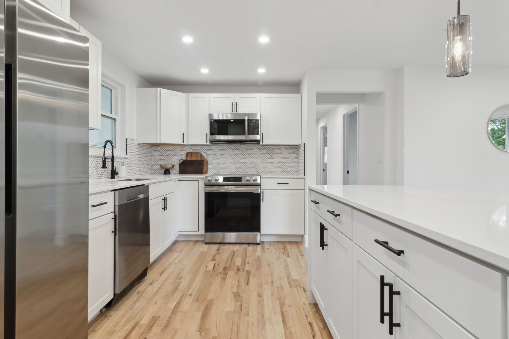 Full kitchen remodel in Aurora with white shaker cabinets, quartz countertops and peninsula kitchen layout