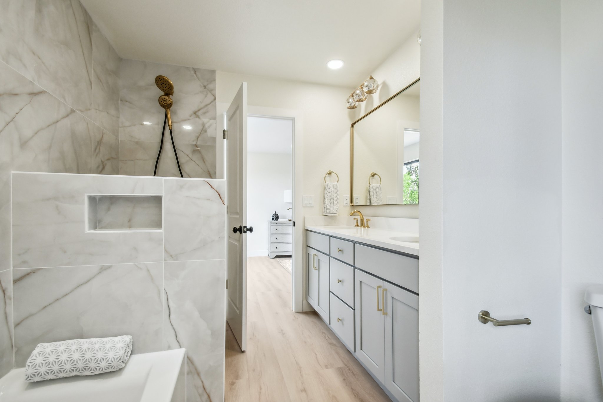 Full bathroom remodel in Centennial with double vanity, large format tile walk-in shower and gold fixtures