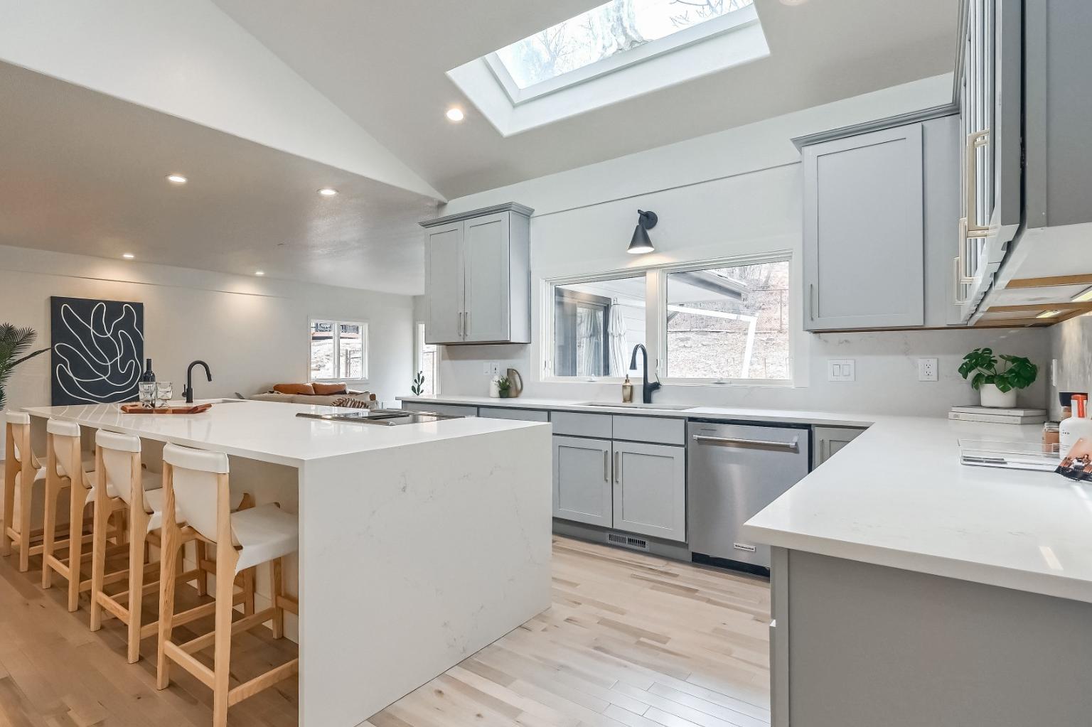 High end custom kitchen remodel in Colorado Springs with 10 foot Calacatta quartz waterfall island and soft gray shaker cabinets
