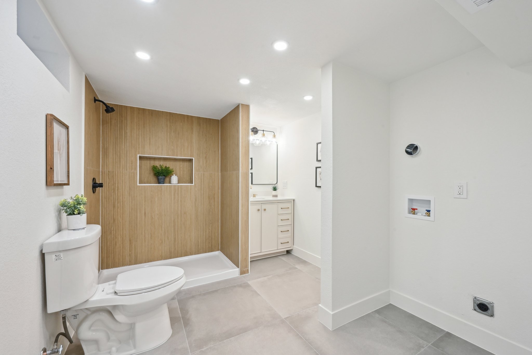 Bathroom and laundry remodel in Denver with wood tone tile shower wall and taupe vanity