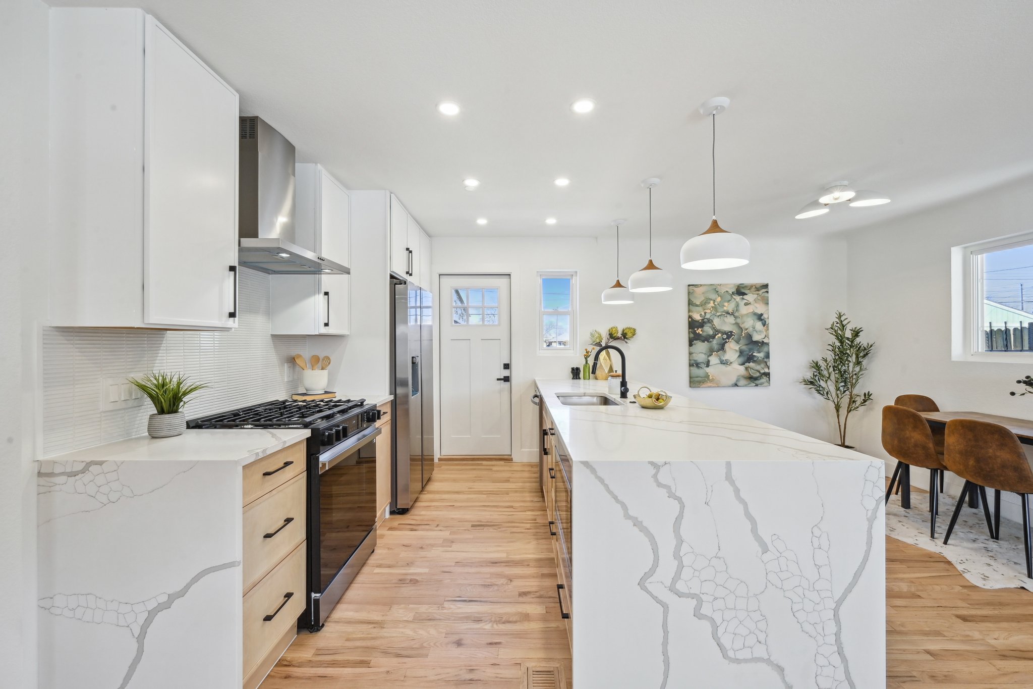 Full kitchen remodel in Denver featuring Calacatta quartz waterfall island and custom slim shaker cabinets with white and wood tone finishes