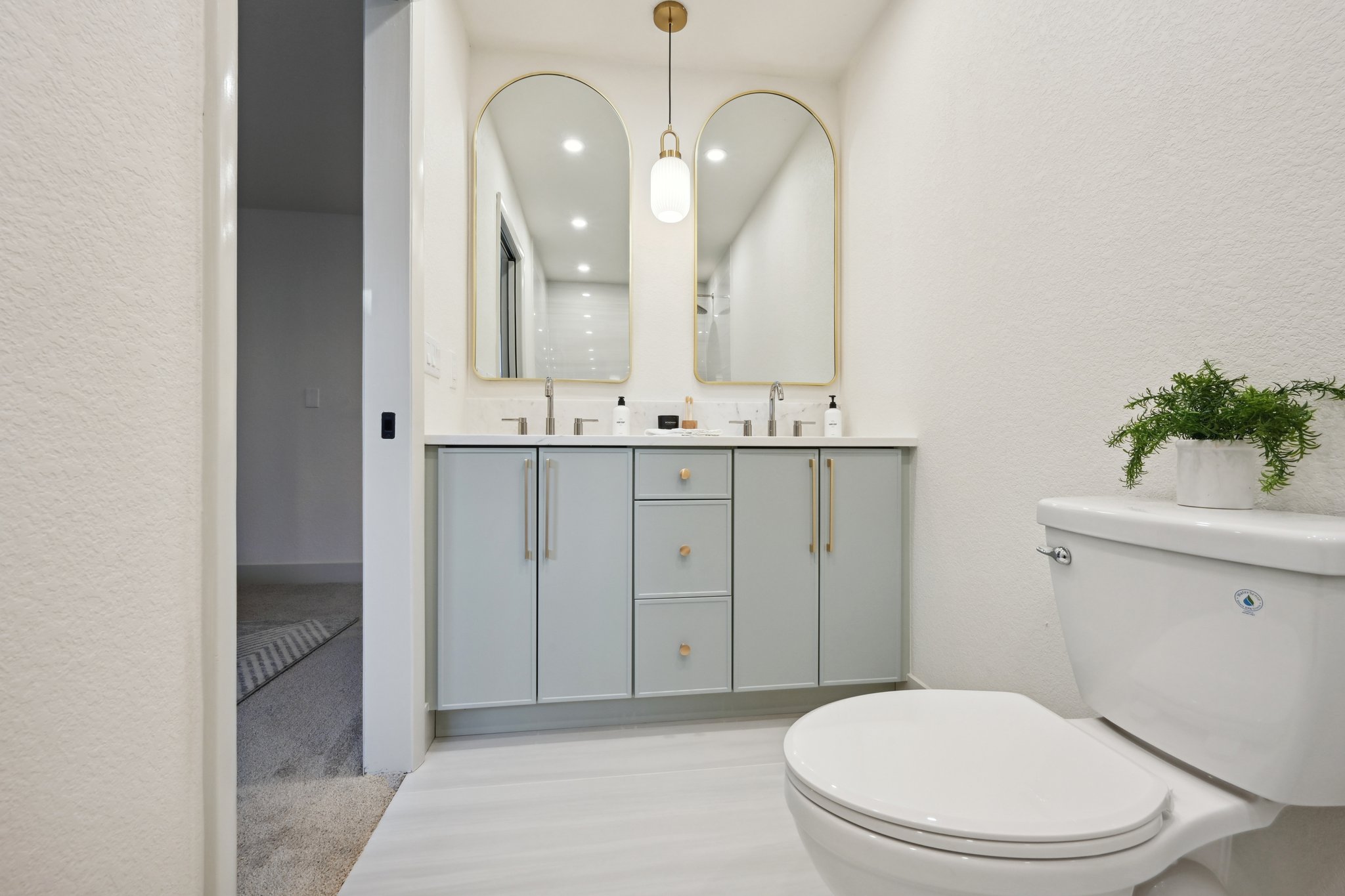 Custom bathroom remodel in Wheat Ridge with aloe double vanity, extra tall arched mirrors and large format tile