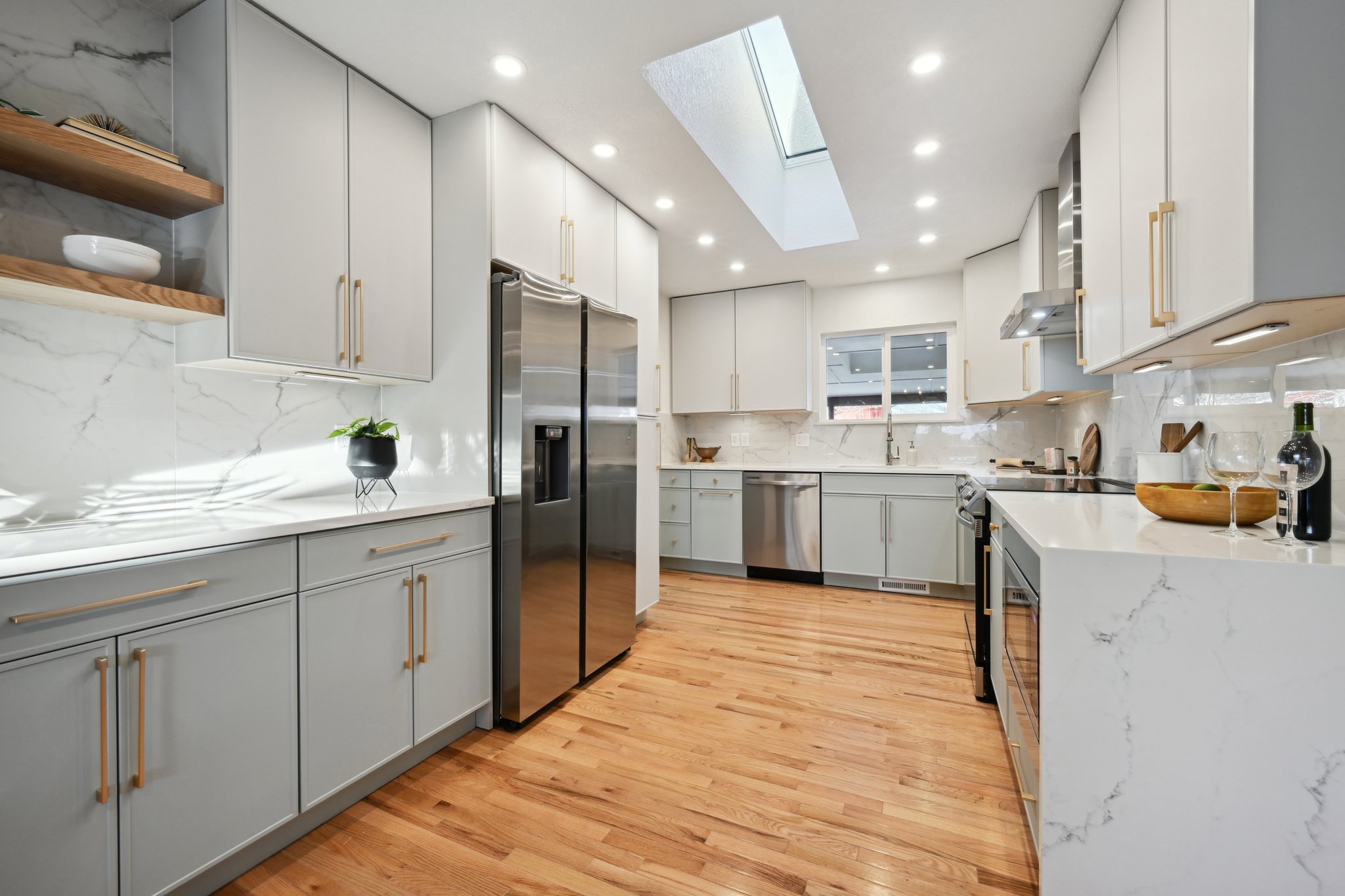Two tone slim shaker kitchen remodel in Wheat Ridge Colorado with light gray and aloe custom cabinets and Calacatta quartz waterfall countertop